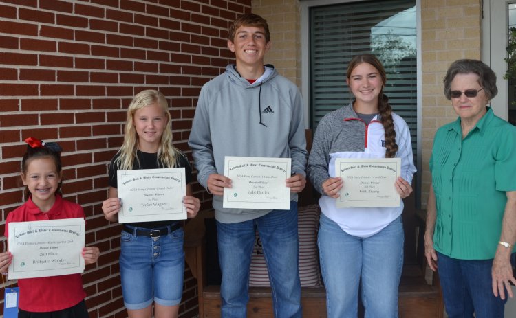 Shiner Catholic Schools had four students place in the Lavaca Soil and Water Conservation District poster and essay contest. From left are Bridgette Woods, whose poster placed second in district in the K-2nd division, Tenley Wagner, whose essay placed first in the 13 and under division, Gabe Darilek, whose essay placed second in the 14 and over division, Faith Brown, whose essay placed third in the 14 and over divisions, and LSWCD secretary Dorothy Henke. Photo by Jimmy Appelt