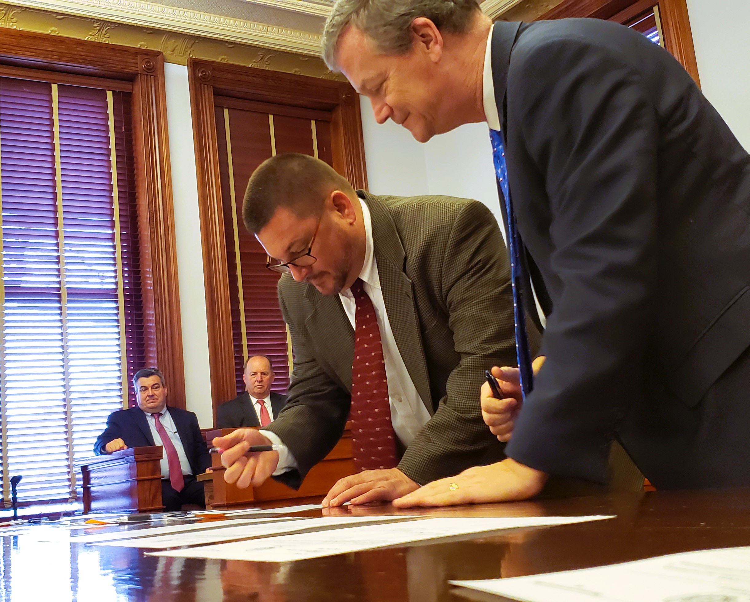 Mark Yackel signs his paperwork to take office.