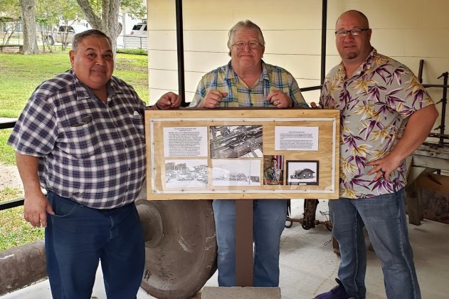 Assistant curator Roy Rivera, curator Duff Wagner and Councilman Greg Murrile pose for a picture to honor Wagner’s official retirement from the city last week. They are standing at the museum’s newest exhibit, featuring one of the massive train trusses and other sordid details about the big train derailment that took place in downtown Shiner earlier this summer. 